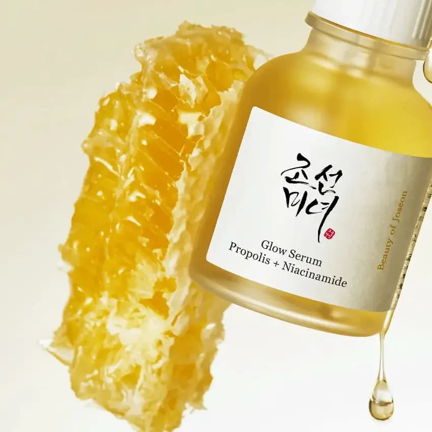 Sérum dorado de propóleo junto a un panal de miel
